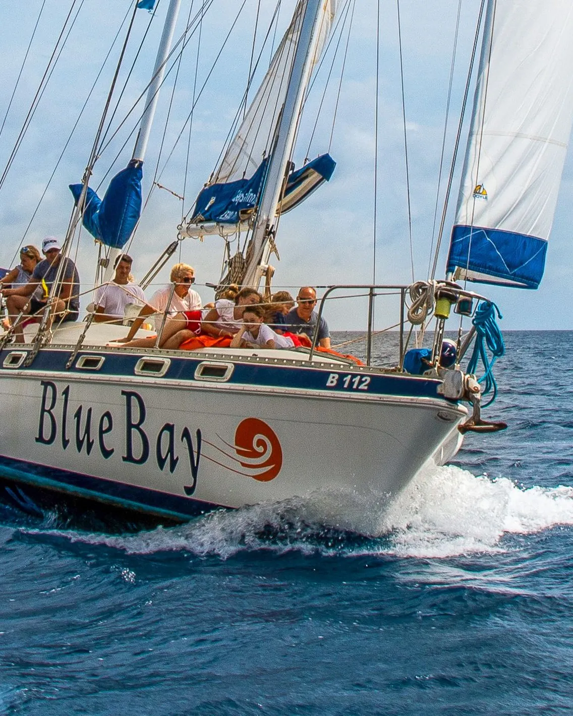 De zeilboot van Blue Bay Bonaire onder vol zeil, met gasten aan dek